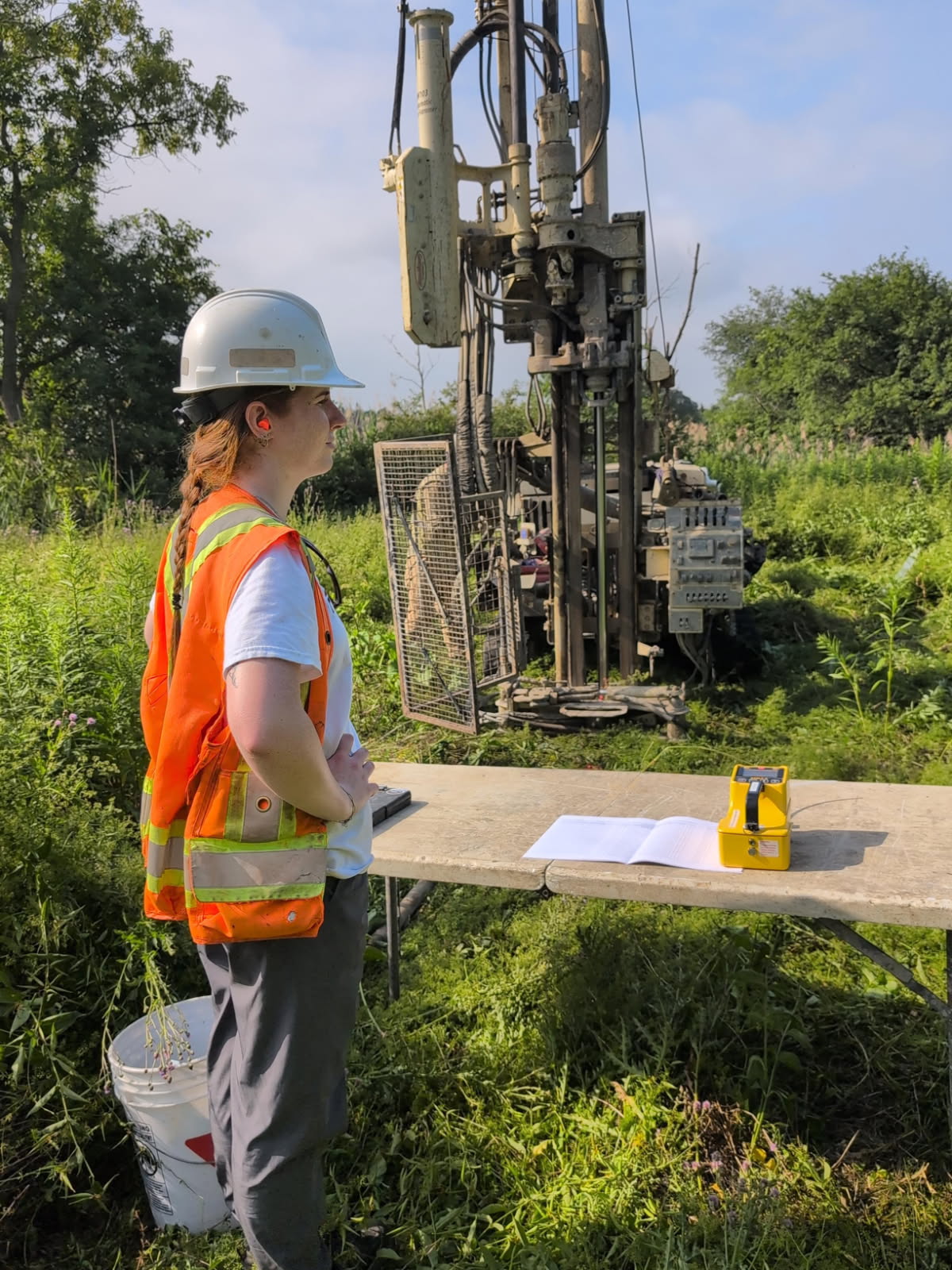 Environmental Professional overseeing a Phase Two ESA drill job in a field