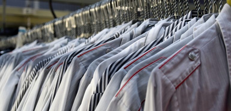 Pressed collared shirts hanging at a dry cleaner