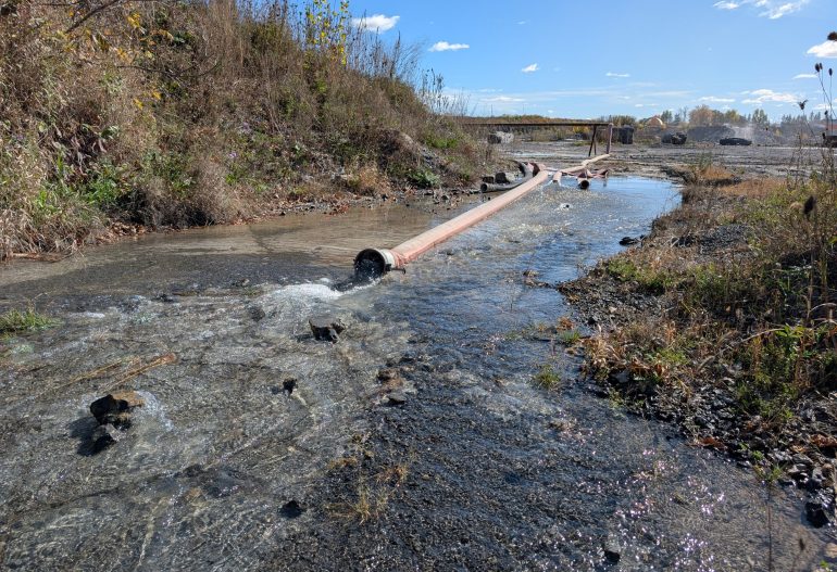 Large hoses with water draining out - Dewatering a Quarry